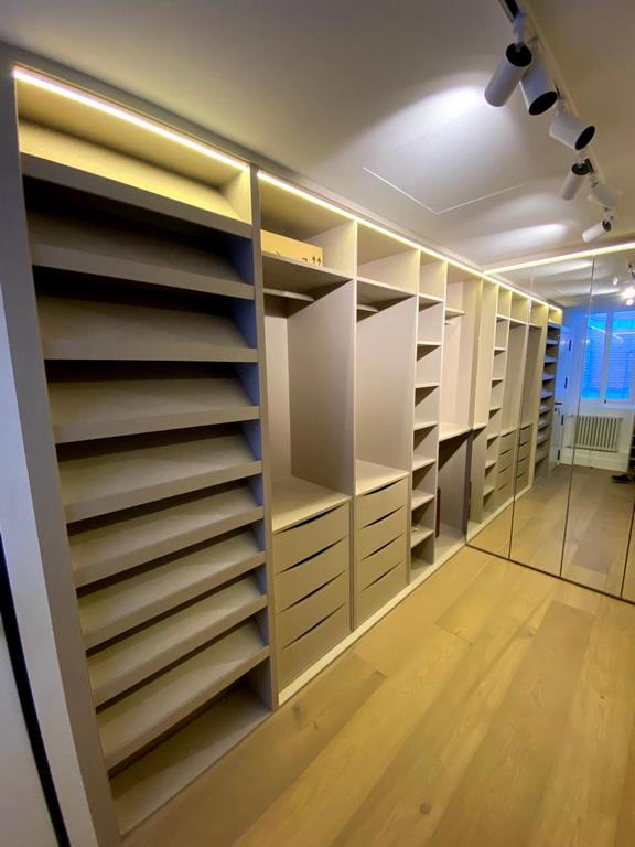 Vestidor abierto en pasillo con zapatero de baldas inclinadas y espejo lateral — R Y M, Madrid